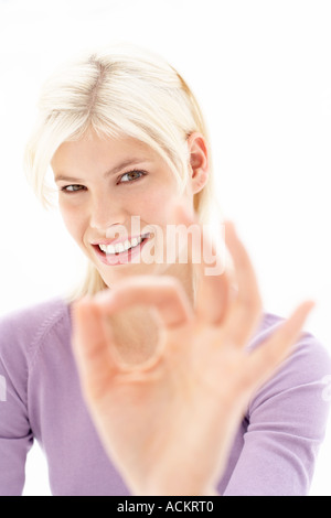 Eine junge Frau macht ein Handzeichen Stockfoto