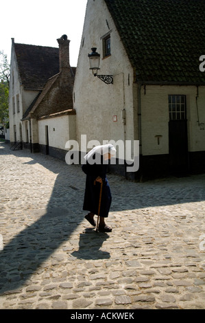 Ältere Nonne aus dem Kloster auf ihrem Weg zur Kirche in der Altstadt von Brügge in den Niederlanden, Europa Stockfoto