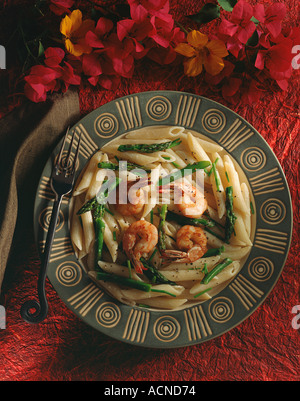 Penne-Nudeln serviert in einer würzigen Primavera Sauce mit Baby Spargelspitzen und gegrillte Garnelen Stockfoto