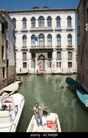 Mann im Motorboot Lenkung durch Kanal Straßen von Venedig, Italien. Stockfoto