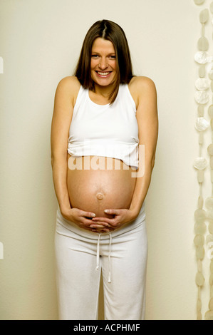 Schwangere Frau mit Händen am Bauch Stockfoto
