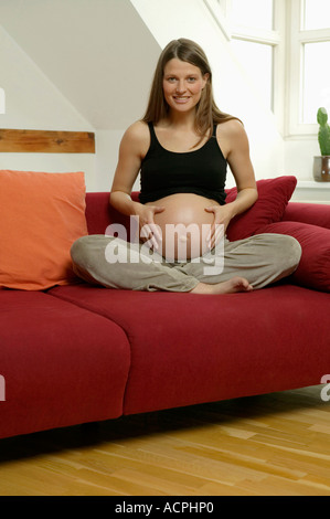 Schwangere Frau mit Händen am Bauch Stockfoto