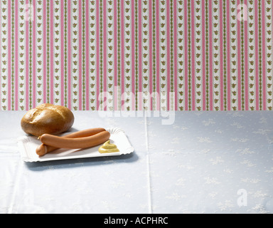 Wiener mit Senf und Brot Rollen auf Tisch Stockfoto