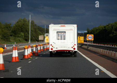 stecken hinter eine Karawane durch Baustellen und Leitkegel im Anschluss an die Autobahn M2 in Nordirland Stockfoto
