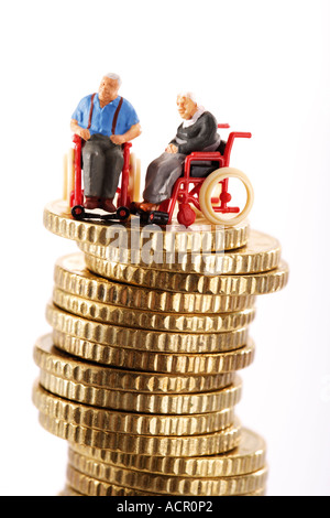 Figuren im Rollstuhl auf Haufen von Münzen Stockfoto