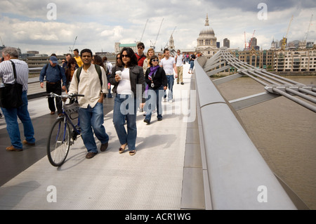 Menschen zu Fuß auf der Millenium Brücke über den Fluss Themse in London, UK Stockfoto