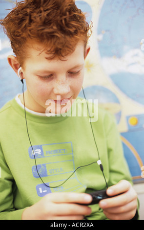 Jungen (8-9) MP3-Player anhören Stockfoto