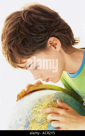 Jungen (9-10) suchen im Globe, Porträt Stockfoto