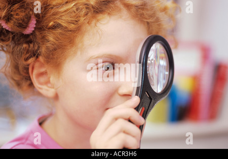 Mädchen (6-7) Blick durch die Lupe, erhöht, Ansicht Stockfoto