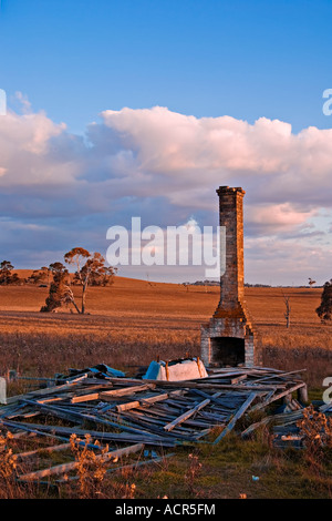 Dieses alte Bauernhaus übrig ist ist ein Kamin ein Haufen Holz und einem umgedrehten Bad Stockfoto