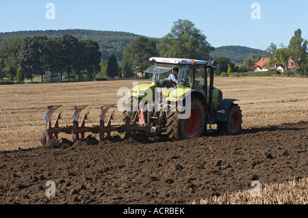 Zugpflug mit Green Claas-Traktoren (Stoppelpflügen, Drehen von Boden und Schlamm, Vorbereitung von Land, Fahren von Landarbeitern) – West Yorkshire, England, GB. Stockfoto