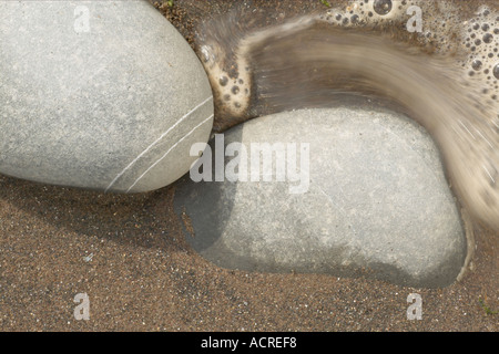 Kieselsteine, die durch die Flut Stockfoto