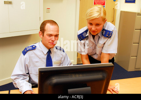 Police Community Support Officers Blick auf Computer-Bildschirm in neu eröffneten sicherer Nachbarschaft Büro, Wimbledon, London, UK. Stockfoto