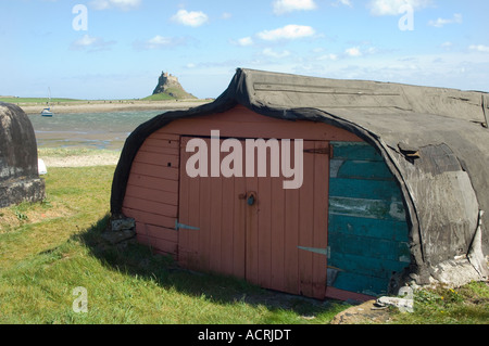Fishermans Hütte aus mit umgedrehten Boot und Lindisfarne Castle in Ferne, Lindisfarne, Northumberland, UK Stockfoto