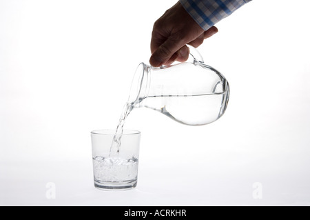 Reines Trinkwasser gegossen aus einem Krug in ein Glas (kleine Kanne & Glas) Stockfoto