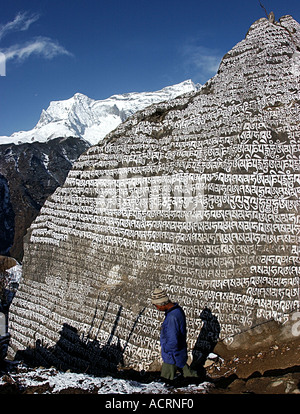 Ein Sherpa geht vorbei an einen riesigen Mani-Stein in der Ortschaft von Namche Bazaar Khumbu Tal Nepal A tibetisch-buddhistischen Tradition Mani Stockfoto