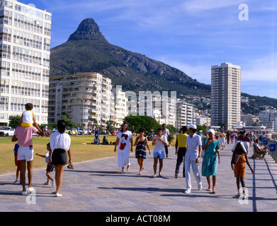 Fußgänger und Familien schlendern Sie entlang der Strandpromenade in Sea Point, am Strand von Kapstadt Kapstadt Stockfoto