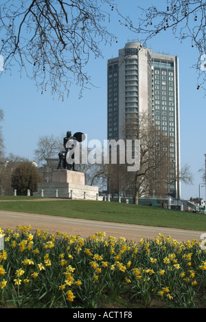 Winterbaum Narzissen & Achilles Statue im Hyde Park erinnern Duke of Wellington mit Hilton Hotel Wolkenkratzer Gebäude in Park Lane London, Großbritannien Stockfoto