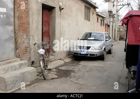 Fahrradrikscha geht Auto geparkt in der Hutong in Peking Stockfoto