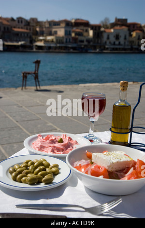 Griechisches Essen und trinken-Salat mit Feta-Käse Taramasalata grüne Oliven Olivenöl und Glas Rot Wein Chania Hafen Kreta Stockfoto