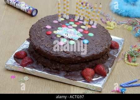 Schokoladenkuchen mit farbigen Zucker geschält, Scheiben und Kerzen Stockfoto