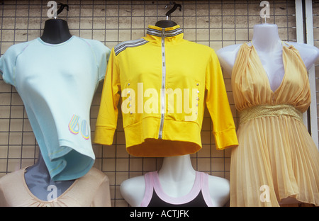 Detail der ziemlich billig suchen Damen Kleider hängen auf dem Display vor Geschäft sowie T-shirt Party-Kleid und Jacke Stockfoto