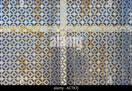 Detail der kunstvoll geschnittener Metall Silber Bildschirm aber mit einigen Rostflecken, die Bereitstellung von Sicherheit oder Privatsphäre zum Fenster direkt hinter Stockfoto