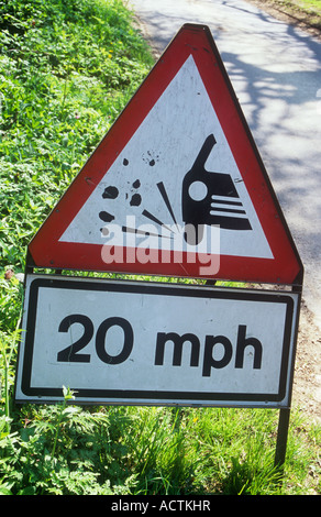 Rote weiße und schwarze Zeichen auf Grünstreifen der Gasse Warnung vor losen Splitt und Beratung von max. Höchstgeschwindigkeit 20 km/h Stockfoto