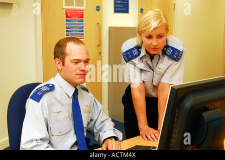 Police Community Support Officers Blick auf Computer-Bildschirm an der neu eröffneten sicherer Nachbarschaft Büro, Wimbledon, London UK. Stockfoto