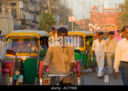 Typische Straßenszene entlang Chandni Chowk mit Auto und Zyklus Rickshaws und das Rote Fort (Lal Qila) im Hintergrund. Stockfoto