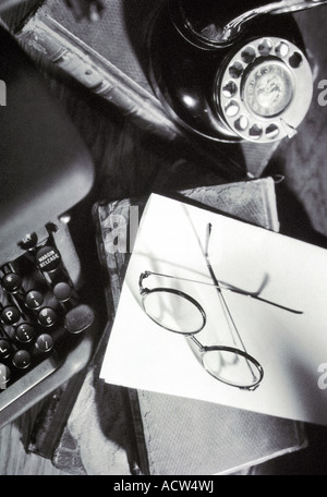 Alte Schreibmaschine auf Schreibtisch Bücher Telefon Gläser horizontale Stockfoto