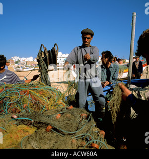 PORTUGAL ALGARVE ARMACO DE PERA FISCHER SORTIERUNG FISCHERNETZE AM STRAND Stockfoto