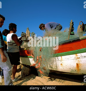 PORTUGAL ALGARVE ARMACO DE PERA FISCHER FISCHE ANGELN NET AM STRAND SAMMELN Stockfoto