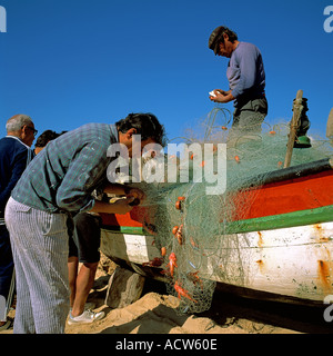 PORTUGAL ALGARVE ARMACO DE PERA FISCHER FISCHE ANGELN NET AM STRAND SAMMELN Stockfoto