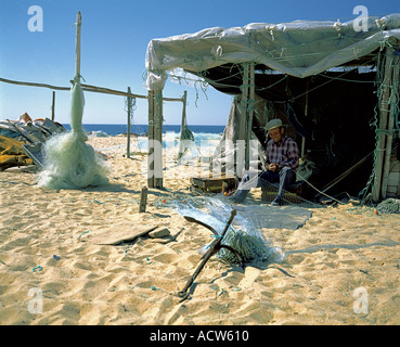 PORTUGAL ALGARVE ARMACO DE PERA FISCHER FLICKEN EIN FISCHEREI-NETZ AM STRAND Stockfoto