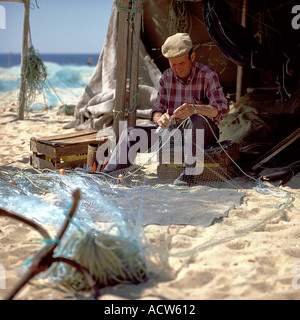 PORTUGAL ALGARVE ARMACO DE PERA FISCHER FLICKEN EIN FISCHEREI-NETZ AM STRAND Stockfoto