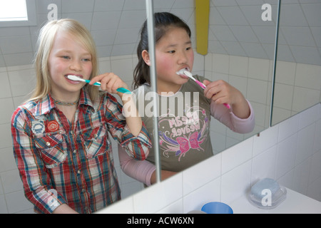 Zwei Girs sind ihre Zähne putzen. Stockfoto