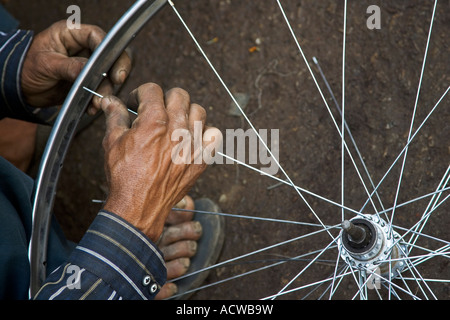 Zwei Hände, die Befestigung ein Fahrrad Rad Varanasi Benares Indien Stockfoto
