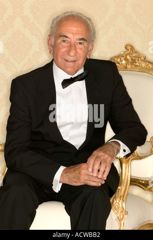 Älterer Mann sitzt im Sessel Stockfoto