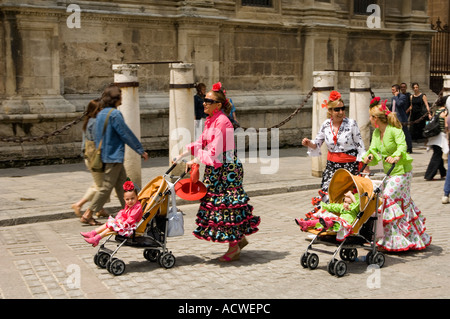 Frauen und Kinder in traditioneller Kleidung außerhalb der großen gotischen Kathedrale von Sevilla, Andalusien, Spanien, während der Feria Stockfoto