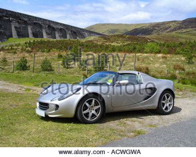 Ein Silber Lotus-Sportwagen vor einem Damm in der schottischen Landschaft Stockfoto