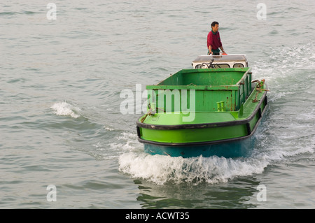 leere grüne Müll Boot auf dem Weg zur Arbeit von einem italienischen Müll Mann auf Venedig Canal pilotiert Stockfoto