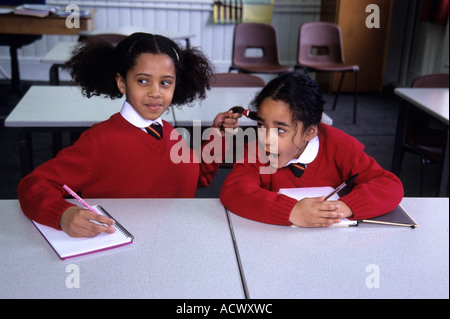 Störenden Einfluss eine Schulmädchen zieht ihr Klassenkamerad Haar und erwischt Stockfoto