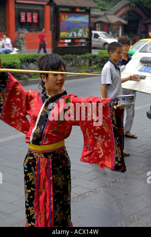 Ein Store-Demonstrator in traditioneller Tracht auf Qintai Straße Stockfoto