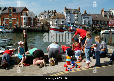 Angeln für Krabben auf dem Kai Urlauber in Weymouth Dorset England UK Stockfoto