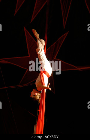 Acrobat Zirkuskünstler verheddert in roten Vorhänge Stockfoto