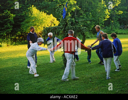 Familie Tanz um den Maibaum in Schweden während kleine traditionelle Mittsommer-Feier Stockfoto