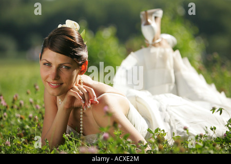 Porträt einer Braut im Blumenfeld Lächeln auf den Lippen liegen Stockfoto