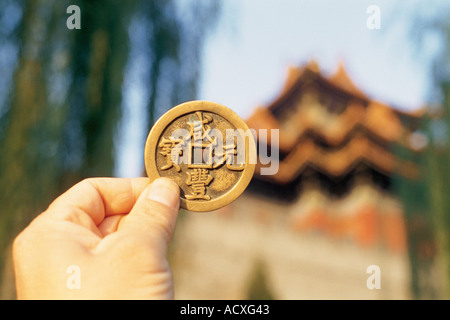 eine Hand hob eine chinesische antike Münze Stockfoto