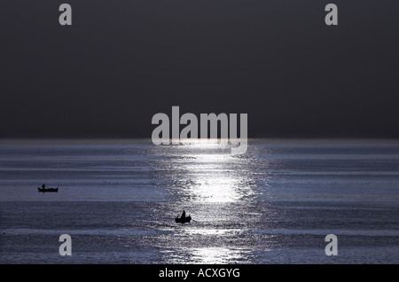 Am Abend angeln Mondschein beleuchtet zwei kleine Fischerdorf Dingys in der Bucht von Ortygia Insel Syrakus Stockfoto